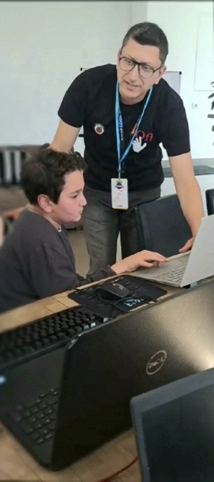 Mr. Roger mentoring a student working on a laptop